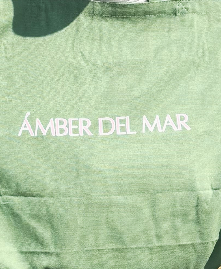 Large seafoam green canvas tote bag with light pink Ámber Del Mar logo.